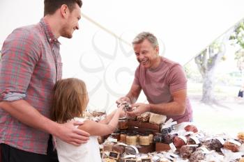 Family Buying Nuts From Stall At Farmers Market