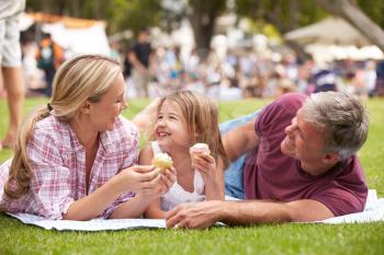 Family Enjoying Cupcakes At Outdoor Summer Event