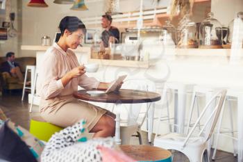 Businesswoman using tablet in a coffee shop