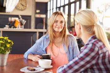 Two female friends talking at a coffee shop
