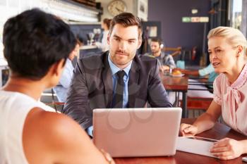 Group of business people with laptop meeting in coffee shop