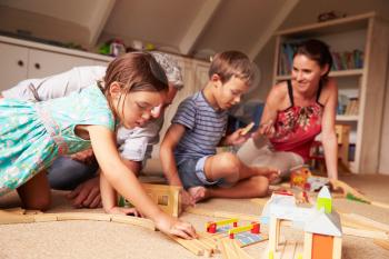 Parents playing with kids and toys in an attic playroom