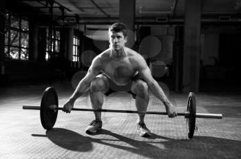 Black And White Shot Of Man Preparing To Lift Weights