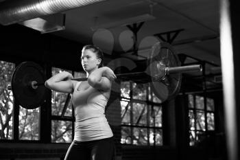 Black And White Shot Of Woman In Gym Lifting Weights