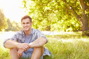 Young man sitting on grass relaxing
