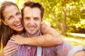 Happy young adult couple relaxing in the countryside, portrait