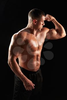 Male bodybuilder looking at his flexing muscles