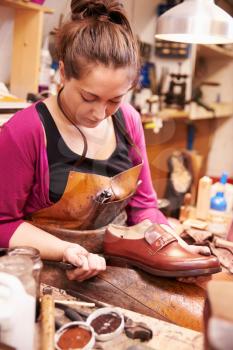 Woman shoemaker making shoes in a workshop