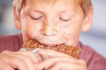 Close Up Of Boy Eating Bar Of Chocolate