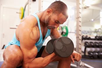 Man exercising with dumbbells at a gym, horizontal shot