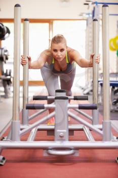 Woman working out using equipment at a gym, vertical