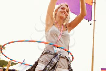 Blonde woman dancing with hula hoop at a music festival