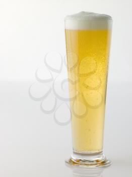 Glass Of Foaming Beer On White Background