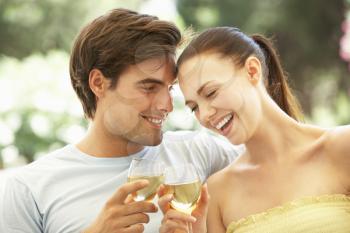 Portrait Of Young Couple Relaxing On Sofa Drinking Wine Together