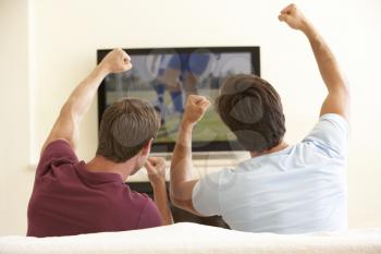 Two Men Watching Widescreen TV At Home