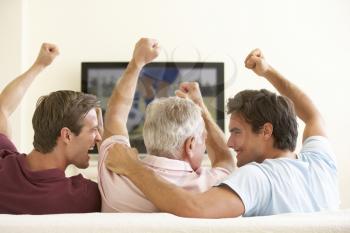 Three Men Watching Widescreen TV At Home