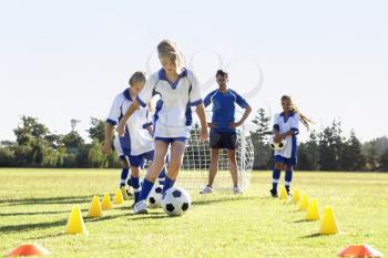Group Of Children In Soccer Team Having Training With Coach