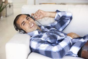 Young Man Relaxing Listening To Music At Home