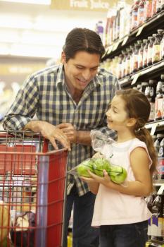 Father and daughter buying fruit in supermarket