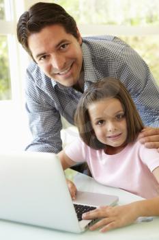 Hispanic Father And Daughter Using Laptop