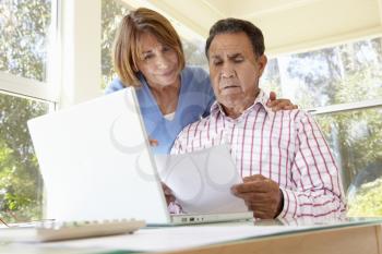 Senior Hispanic Couple Working In Home Office