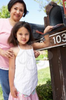 Hispanic Grandmother And Granddaughter Checking Mailbox