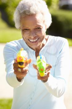 Senior Woman Shooting Water Pistols