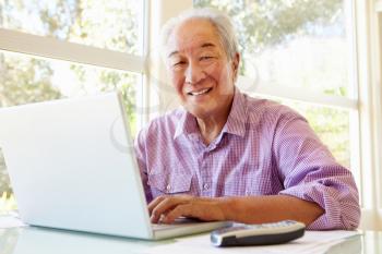 Senior Taiwanese man working on laptop