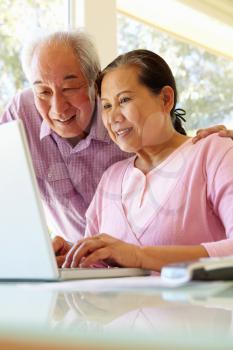 Senior Taiwanese couple working on laptop