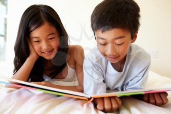 Young Asian girl and boy reading book