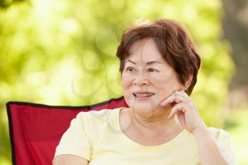 Senior Asian woman sitting outdoors