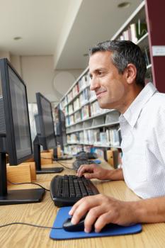 Man working on computer in library