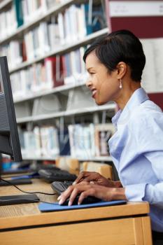 Woman working on computer in library