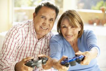 Senior Hispanic Couple Playing Video Game At Home