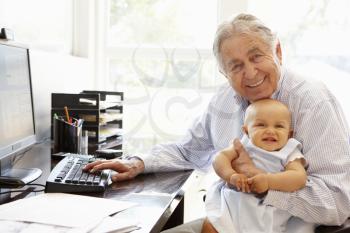 Senior Hispanic man with computer and baby