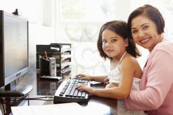 Senior Hispanic woman with computer and grandchild