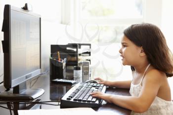 Young Hispanic girl using computer at home