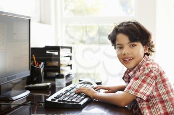 Young Hispanic boy using computer at home