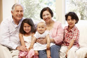 Hispanic grandparents at home with grandchildren