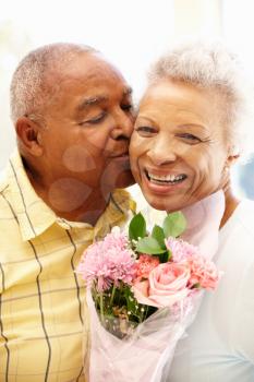 Senior man giving flowers to wife