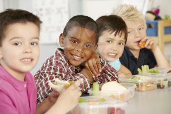 Group Of Elementary Age Schoolchildren Eating Healthy Packed Lunch In Class 