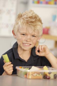 Elementary Age Schoolboy Eating Healthy Packed Lunch In Class 