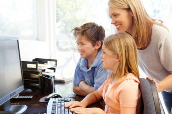 Mother and children using computer at home