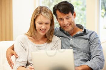 Couple using laptop at home