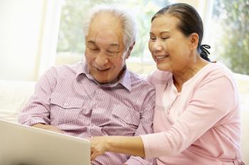 Senior Asian couple using laptop