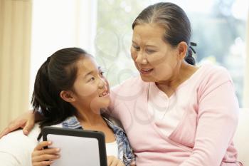 Senior Asian woman and granddaughter with tablet