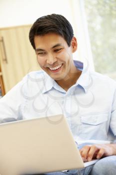 Asian man using laptop at home
