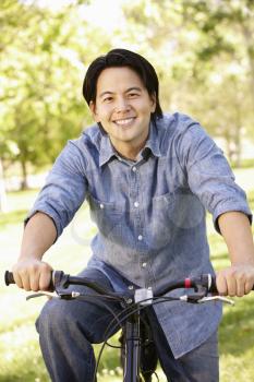 Asian man riding bike in park
