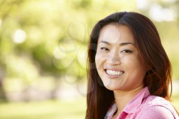 Head and shoulders portrait Asian woman outdoors