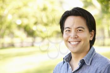 Head and shoulders portrait Asian man outdoors